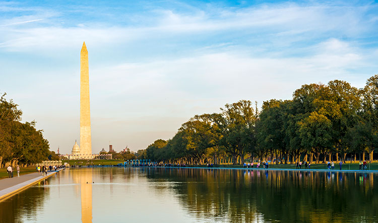 A wide shot of the Washington Monument and reflecting pool.