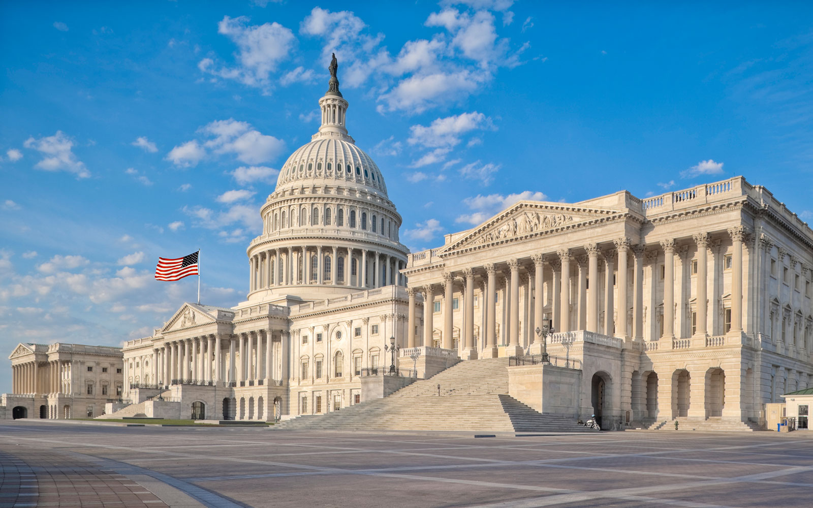 The US Capitol building with a large staircase and American flag