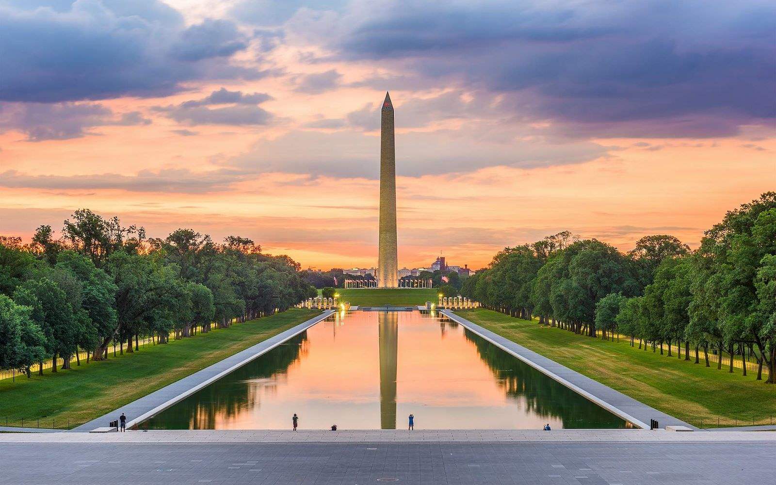 A wide shot of the Washington Monument and reflecting pool at sunset.