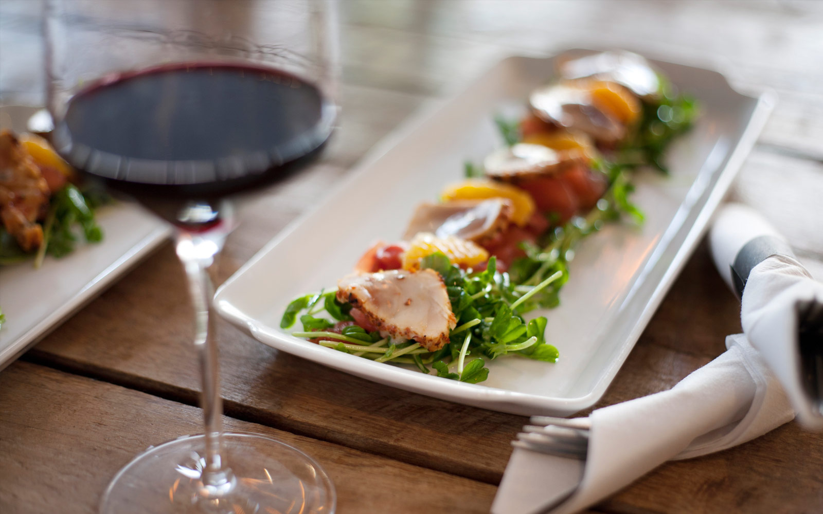 a plate of food and a glass of wine on a table
